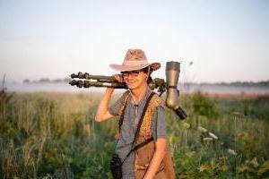 Person with large camera in wetlands